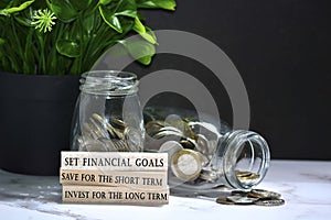 Text on wood block with Australia dollar and European coins on table surface
