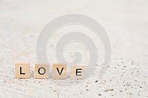 Text wooden blocks spelling the word LOVE on concrete floor with