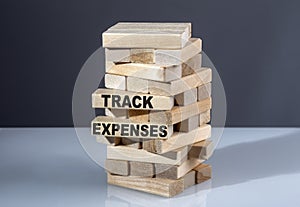 The text on the wooden blocks TRACK EXPENSES