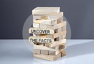 The text on wooden blocks UNCOVER THE FACTS