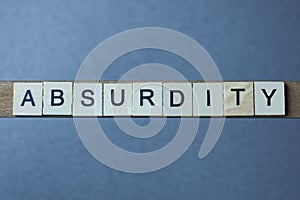 Text the word absurdity from brown wooden small letters