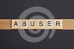 Text on word abuser from gray wooden letters