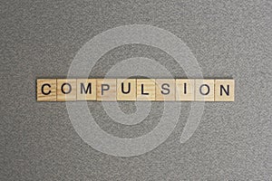 Text the word compulsion from gray wooden small letters