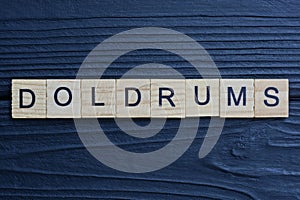 text the word doldrums from brown wooden small letters
