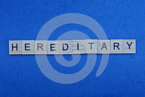 The text of the word  hereditary from small gray wooden letters