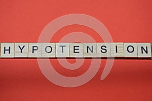 Text the word hypotension from gray wooden small letters