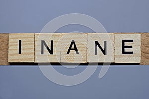 Text the word inane from brown wooden small letters