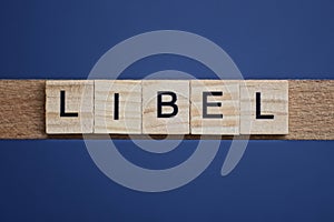 Text the word libel from brown wooden small letters