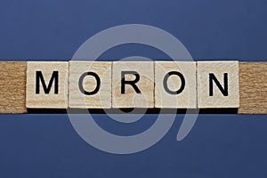 Text the word moron from brown wooden small letters photo