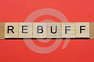 Text the word rebuff from gray wooden small letters