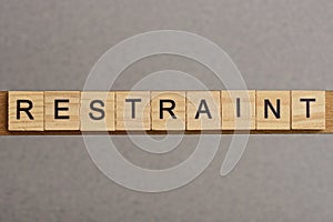 Text the word restraint from brown wooden small letters