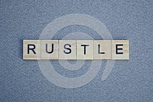 Text the word rustle from brown wooden small letters photo