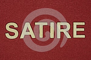 Text the word satire from gray wooden small letters
