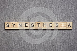 Text the word synesthesia from brown wooden small letters