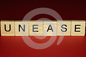 Text the word unease from gray wooden small letters