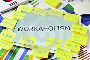 The text workaholism in a tablet on an office desk photo