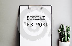 Text written on clipboard with holder. Lettering is important to promote your business. The inscription SPREAD THE WORD.