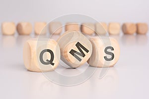 text 'QMS' - Quality Management System - on wooden cubes photo