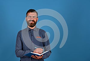 Textbook in blue color in guys hands on blue background