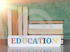 textbooks on desk in front of blurred blackboard