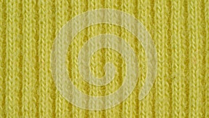 Textile background - light yellow cotton fabric with jersey ribbing structure. Macro shoot.