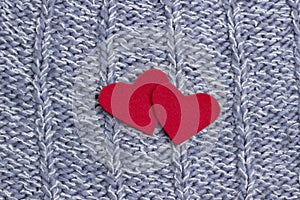Textile background. Two red hearts on the soft knitted blanket. Valentines day concept