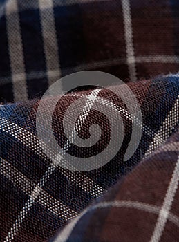 Textile - blue and brown checked shirt fibers close-up, macro photography with volumes