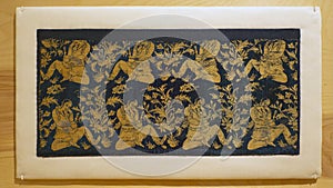 Textile fragment with repeat pattern of a figure ruminating in a Garden on display in the Dallas Museum of Art.