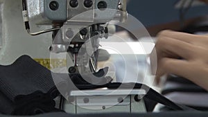 Textile Garment Factory Workers: CU worker feeds fabric into sewing machine