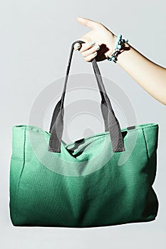 Textile handbag in woman hand. fashion green sport bag