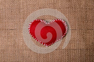 Textile heart on fabric texture of burlap