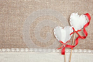 Textile hearts, ribbon and linen cloth on the burlap