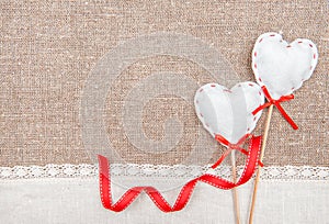 Textile hearts, ribbon and linen cloth on the burlap
