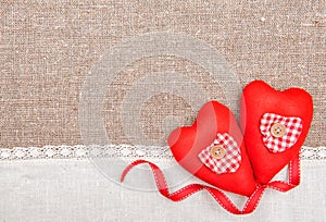 Textile hearts, ribbon and linen cloth on the burlap