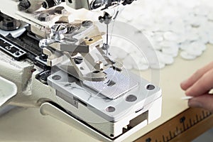 Textile industry, clothing production. Close-up of sewing equipment. Loops and buttons