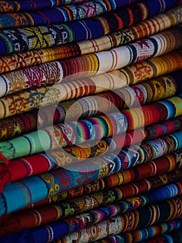 Textile pile colorful traditional andean indigenous handmade woven Otavalo handicraft market Ecuador South America photo