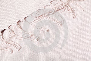 Textile product with long fringe lies on white fabric