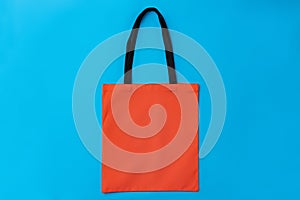 Textile shopping bag on blue paper background flat lay