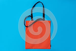 Textile shopping bag on blue paper background flat lay