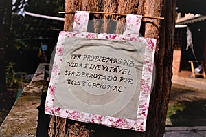 Textile sign written: `Having problems in life is inevitable, being defeated by them is optional`
