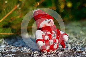 Textile Snowman on the gray wooden surfaces including snow, selective focus