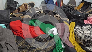 Textile waste at a recycling station. Old clothes and shoes. Fast fashion waste