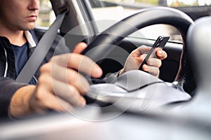 Texting and driving a car. Using mobile phone in traffic. Distracted driver, accident or crash. Irresponsible man typing sms.