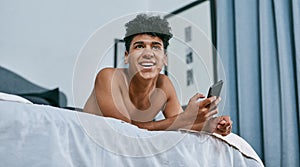 Texting people you never thought youd text, welcome to lockdown. a young man relaxing on his bed and using a smartphone.