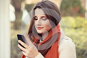 Texting, reading sms. Closeup portrait head shot beautiful young woman girl student looking on mobile phone looking isolated city