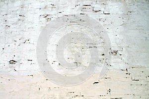 Texture of an ancient brick wall covered with white mortar for the background
