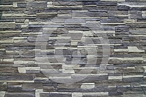 Texture - artificial decorative stone faÃÂ§ade. Decorative grey color rough stone wall background texture.