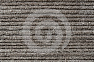 Texture backdrop of beige colored corduroy fabric cloth. Corduroy retro fabric background or texture. Closeup view