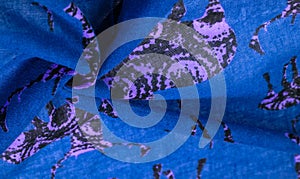 Texture, background, cotton fabric of blue color with a print of deer silhouettes, expensive thin fabric will become the leader of