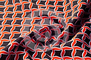Texture, background, pattern. Fabric drawing of a diamond diamond red on a black background